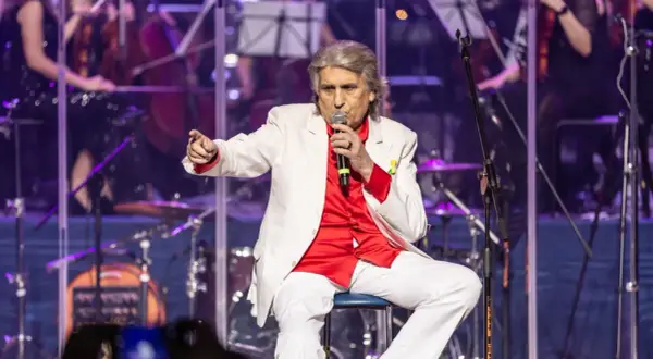 Toto Cutugno, w białej marynarce i czerwonej koszuli, śpiewa "L'Italiano".