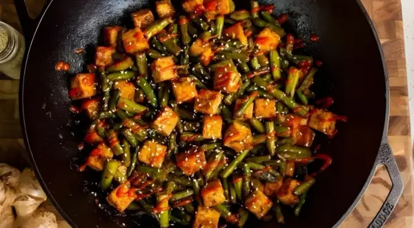 Salteado de verduras con tofu crujiente y sésamo en wok. Un plato vibrante y lleno de sabor.
