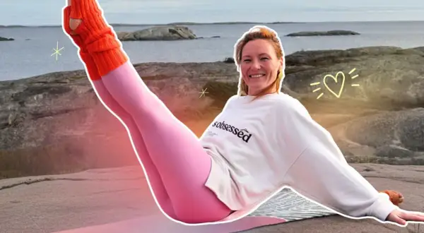 Kobieta w różowych legginsach i pomarańczowych ocieplaczach ćwiczy pilates na zewnątrz.