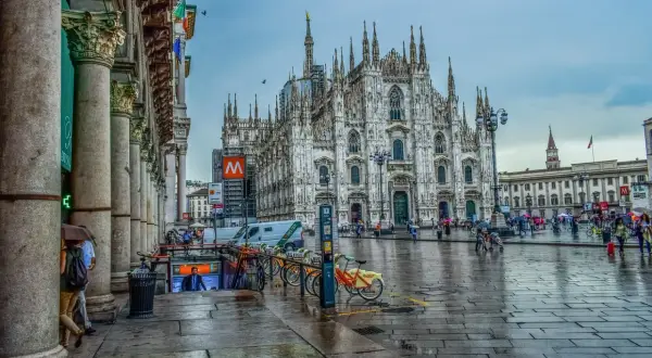 Katedra Duomo w Mediolanie i plac przed nią w deszczowy dzień.
