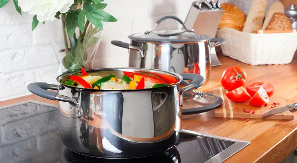 Casserole remplie de légumes colorés sur une plaque à induction, prête à être cuisinée.
