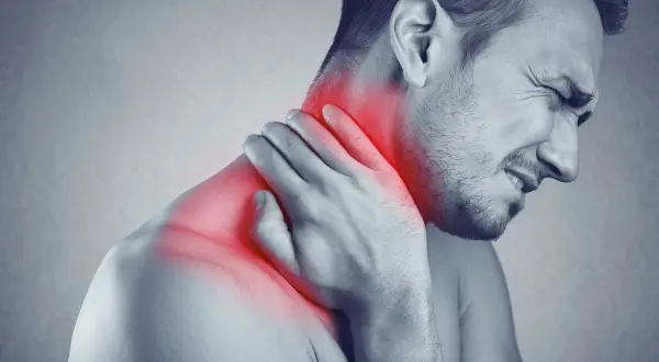 Man med smärta i nacken, möjligen spondylos nacke, håller handen mot det röda, inflammerade området.