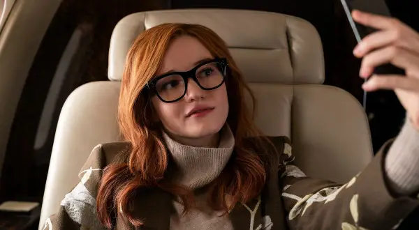 Anna Delvey, grana przez Julię Garner, w luksusowym wnętrzu samolotu, robiąc selfie.