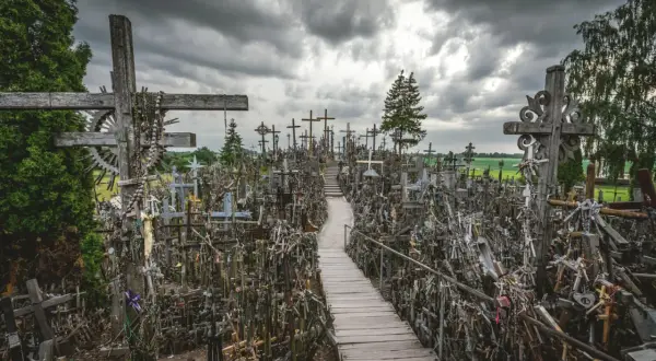 Enorm korskullen i Litauen, fylld med tusentals kors och böner. En stig leder genom den imponerande samlingen.