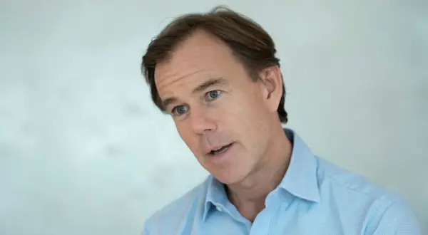Karl-Johan Persson, i ljusblå skjorta, tittar åt sidan med ett engagerat uttryck.
