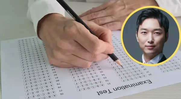 Ręka pisze test, a obok zdjęcie mężczyzny. Czy to on wie, ile iq ma najmądrzejszy człowiek na świecie?