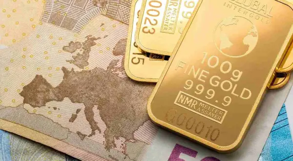Sztabki złota LBMA o próbie 999.9 leżą na banknotach euro.
