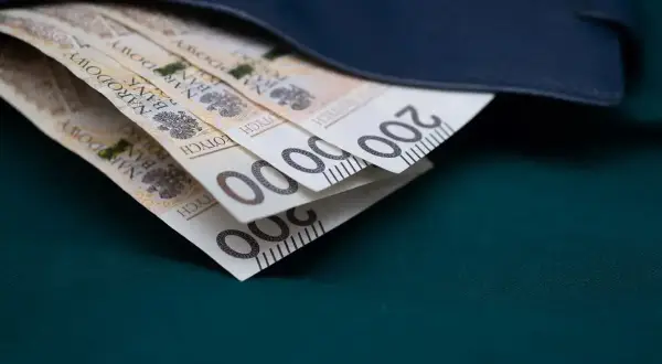 Złote banknoty 200 zł schowane w granatowym portfelu.