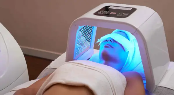 Une femme reçoit un traitement de luminothérapie visage, profitant des bienfaits de cette technologie pour une peau éclatante.