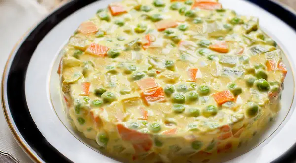 Insalata russa ricetta: un tortino cremoso di patate, carote, piselli e maionese, perfetto per ogni occasione.