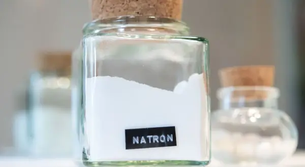 Glasbehälter mit Natron, bereit zum Putzen. Ein weiteres Glas mit Natron steht im Hintergrund.