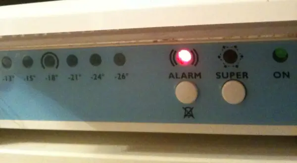 Panel kontrolny zamrażarki Whirlpool z migającą czerwoną diodą ALARM i przyciskami SUPER i ON.