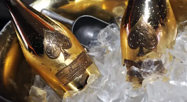 Dwie złote butelki szampana Armand de Brignac w wiaderku z lodem. To szampan drogi, symbol luksusu i celebracji.