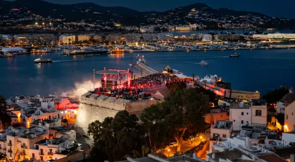 Concerto sul bastione di Dalt Vila, Ibiza, con la baia illuminata e le luci della città. Un evento indimenticabile per chi ama la musica e la magia di IMS Ibiza.