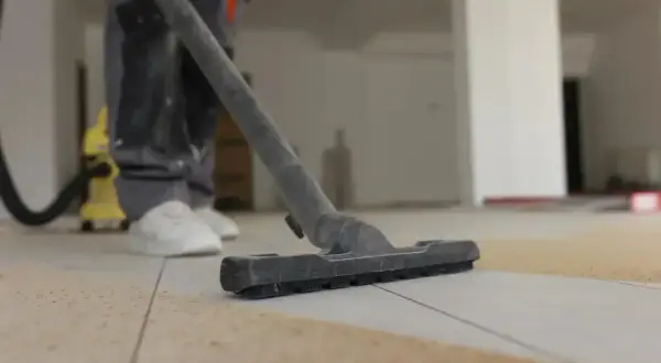 Nettoyage de carrelage après chantier : un aspirateur passe sur le sol pour enlever les débris.