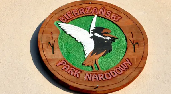 Drewniany symbol Biebrzańskiego Parku Narodowego z ptakiem i napisem.