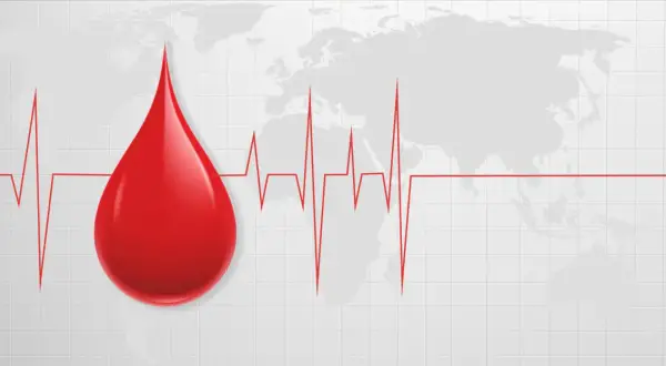 Kropla krwi na tle mapy świata i wykresu EKG. Symbolizuje życie i zdrowie, a także podkreśla, jak cenna jest najrzadsza grupa krwi.