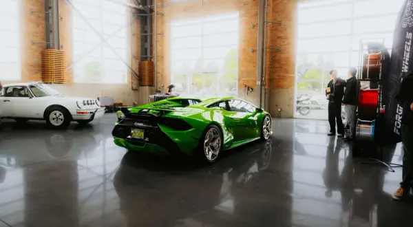 Une Lamborghini verte et une Porsche blanche dans un showroom. Le rachat LOA par concessionnaire est une option pour acquérir ces merveilles.