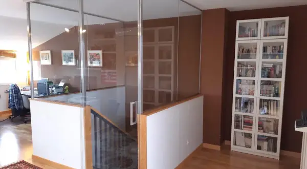 Modern glass enclosure around open stairs, creating a safe and stylish way como cerrar escaleras abiertas.