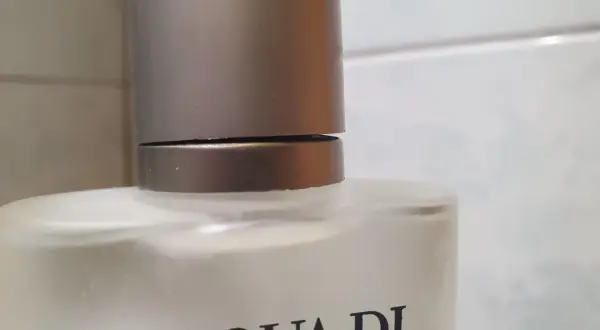 Szklana butelka z napisem ACQUA DI GIO 100ml, z metalową nakrętką.