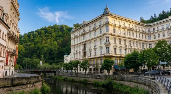 Eleganckie budynki w Karlowych Warach nad rzeką, otoczone zielenią. Urokliwe karlowe wary termy zachęcają do relaksu.