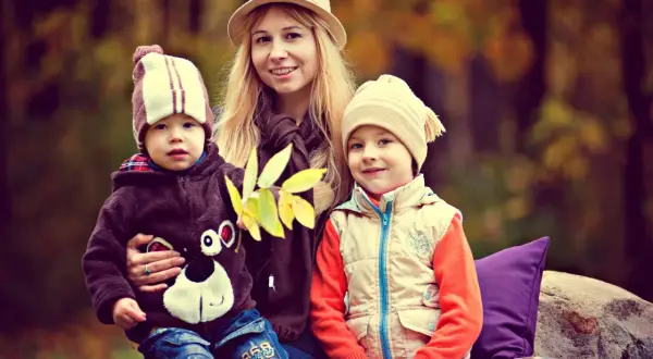Uśmiechnięta mama z dwójką dzieci w jesiennym lesie. Marzy o emeryturze za 4 dzieci, ale na razie cieszy się chwilą.