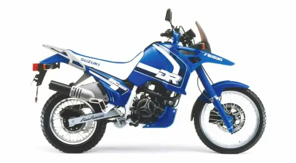 Niebieski motocykl Suzuki DR Big z białymi akcentami, widok z boku.