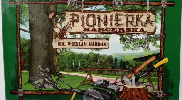 Pionierka harcerska. Drewniany szyld z napisem "PIONIERKA HARCERSKA" i "HM. WIESŁAW GARDAS". W tle las i narzędzia.