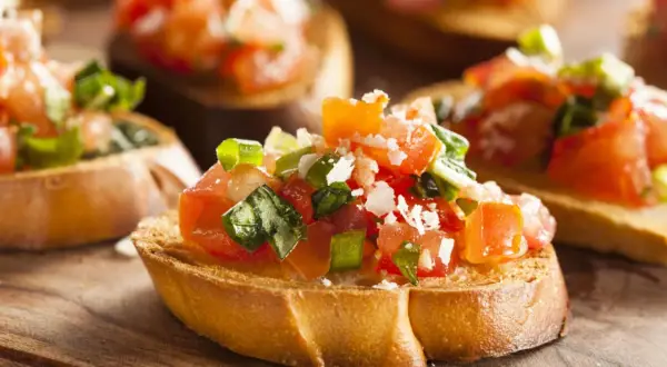 Frisches Bruschetta Rezept: geröstetes Brot mit Tomaten, Basilikum und Parmesan. Köstlich und einfach zuzubereiten!