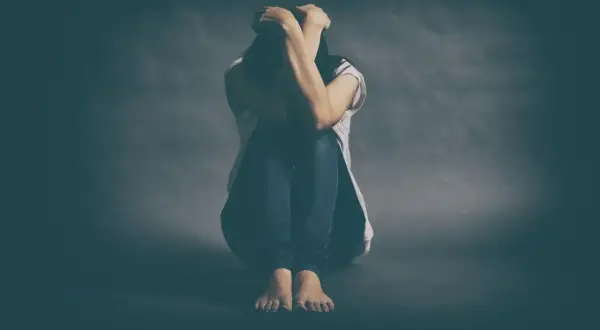 Osoba skulona, z rękami na głowie, symbolizuje walkę z depresją lekooporną.