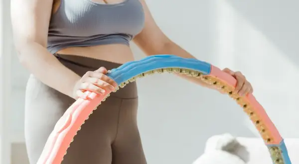 Frau zerlegt einen Hula Hoop Reifen in bunte Segmente.
