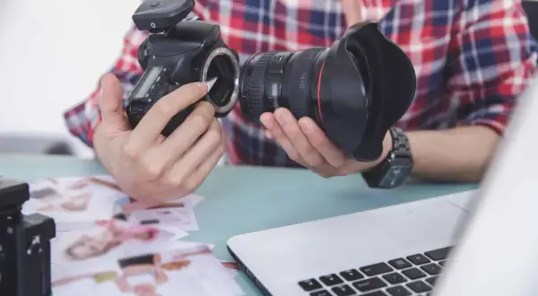 Fotograf przygotowuje sprzęt. Zastanawia się, czy robienie zdjęć z ukrycia jest karalne, przeglądając wydrukowane fotografie.