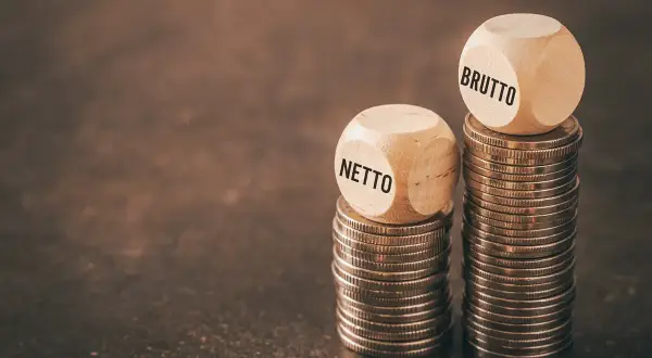 Dwie wieże monet, jedna z kostką "NETTO", druga z "BRUTTO". Czy to odzwierciedla średnią krajową netto?
