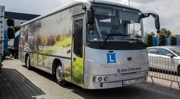 Autosan Lider 10 z literą L na przedzie, symbolizujący naukę jazdy. Sprawdź, jaka jest prawo jazdy kat D cena.