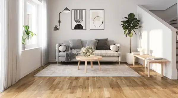 Ljust golv inspiration i ett modernt vardagsrum med grå soffa, rund soffbord och en stor grön växt.
