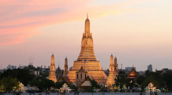 Zachód słońca nad rzeką w Bangkoku, stolicy Tajlandii pełna nazwa. Wspaniała świątynia Wat Arun rozświetlona złotym blaskiem.