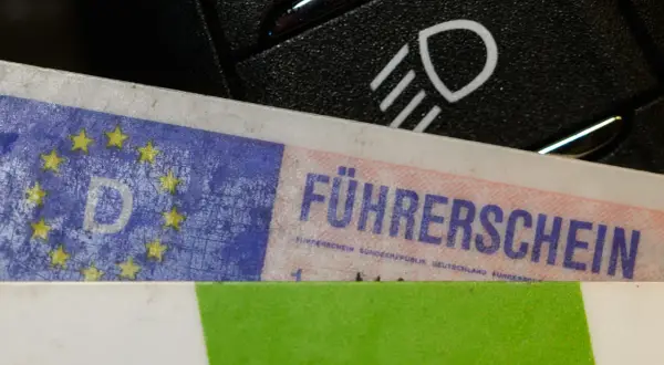 Führerschein mit EU-Sternen und "D" für Deutschland, daneben ein Lichtschalter. Bereit für die Fahrt nach § 24 StVG.
