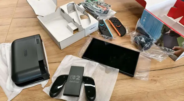 Zawartość pudełka Nintendo Switch: konsola, dwa kontrolery Joy-Con (niebieski i pomarańczowy), stacja dokująca i kable.