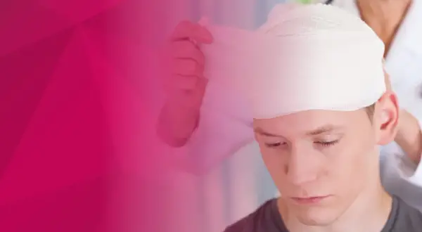 Młody mężczyzna przechodzi bandażowanie głowy przez lekarza.