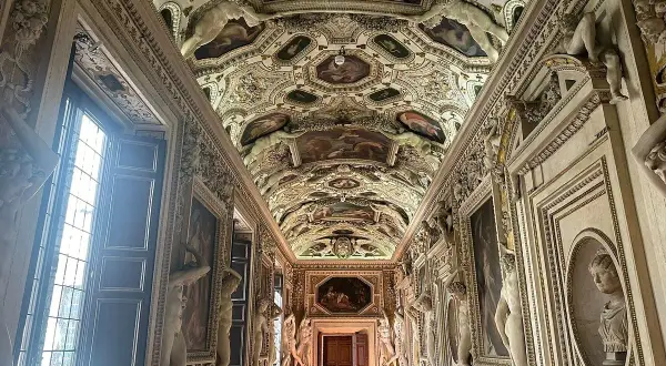 Corridoio decorato con affreschi e sculture nel **Palazzo Spada Roma**. Soffitto a volta con scene mitologiche e figure allegoriche.