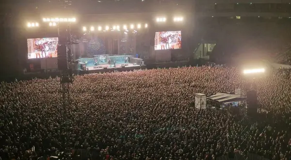 Ogromny tłum na koncercie Iron Maiden w Warszawie. Na scenie zespół, a na telebimach zbliżenia.