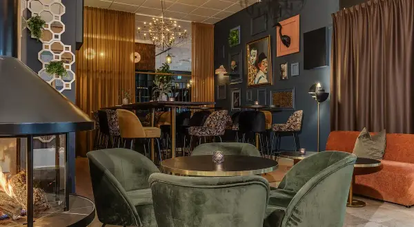 Mysig lounge med eldstad och konst på väggarna. Stadshotellet Ludvika bjuder in till avkoppling.