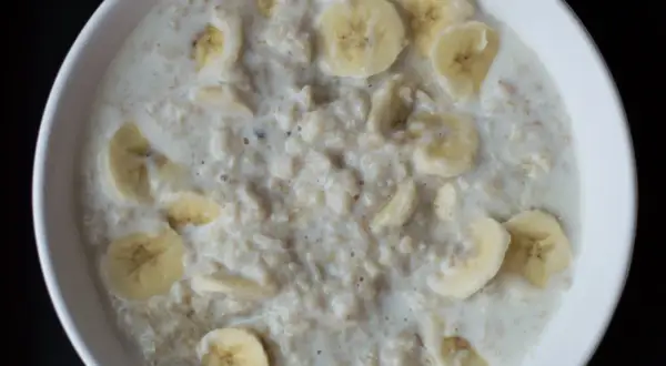 Miseczka owsianki z bananem. Kto nie powinien jeść płatków owsianych? Osoby z nietolerancją glutenu lub celiakią powinny unikać tradycyjnych płatków.