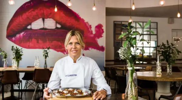 Chef sonríe con un plato de comida en "La Clandestina", uno de los mejores restaurantes Zaragoza centro.
