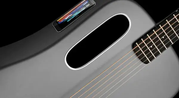 Moderne, graue Klampfe Gitarre mit integriertem Touchscreen und ovalem Schallloch.