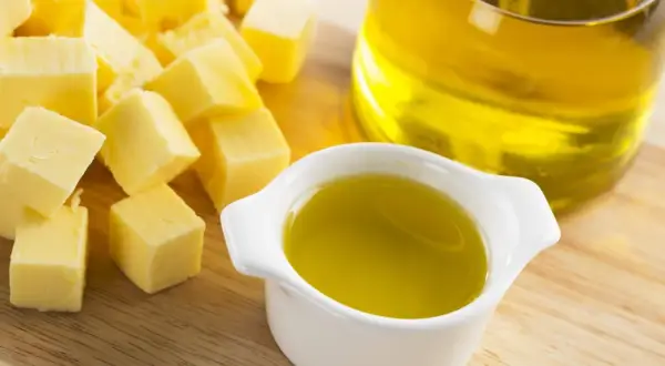 Würfel von Butter und ein Schälchen mit Öl. Fette Chemie für köstliche Gerichte.
