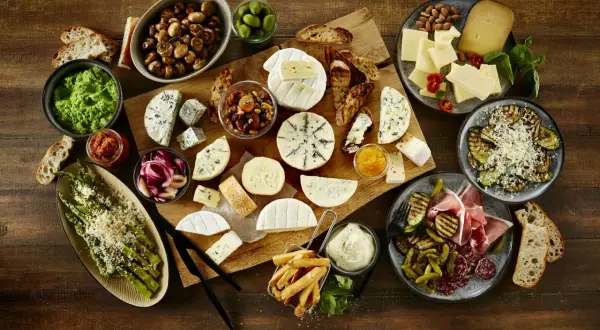 Ein Fest für Genießer: Vielfältige Käsesorten, Oliven, Pilze, Spargel und Aufschnitt laden zu gemütlichen Tapas zuhause ein.