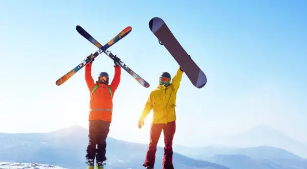 Narciarz i snowboardzista na szczycie góry. Co jest bardziej kontuzyjne narty czy snowboard?