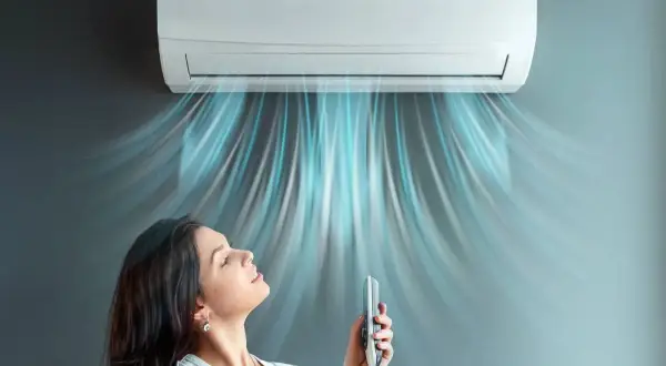 Donna gode dell'aria fresca da un condizionatore 12000 BTU. Il costo installazione condizionatore 12000 btu è un investimento per il comfort.