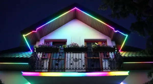 Kolorowa taśma LED w podbitce dachowej tworzy tęczową iluminację wokół domu, dodając mu magicznego blasku.
